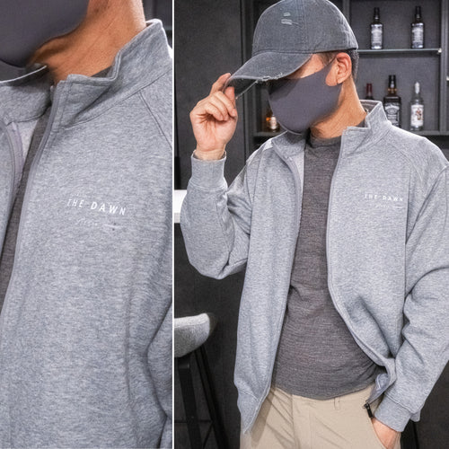 Gray full-zip sweatshirt worn open over a coordinating printed top.